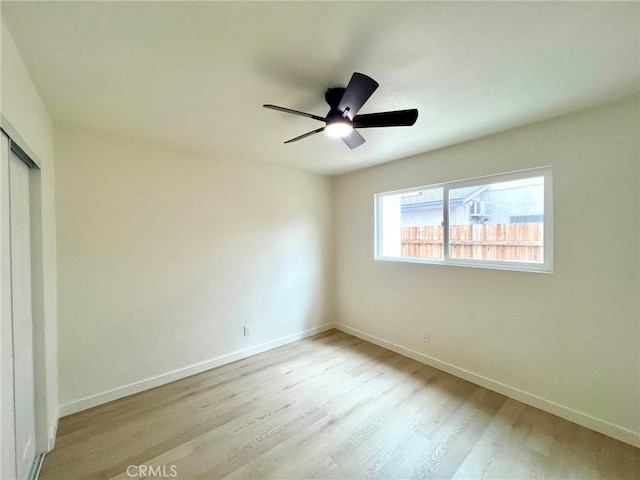 unfurnished bedroom with a closet, ceiling fan, baseboards, and wood finished floors