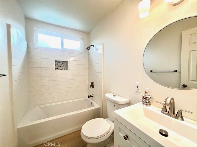 full bathroom featuring wood finished floors, toilet, shower / washtub combination, and vanity