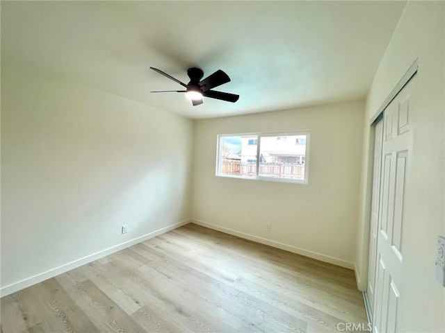 unfurnished bedroom featuring baseboards, light wood-type flooring, a closet, and ceiling fan