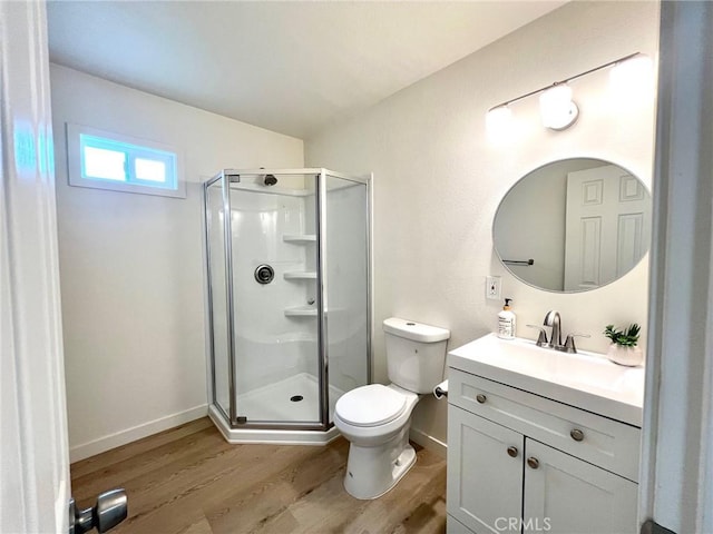 full bath featuring toilet, wood finished floors, a shower stall, baseboards, and vanity