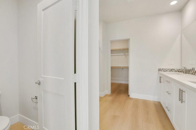 bathroom featuring toilet, wood-type flooring, and vanity