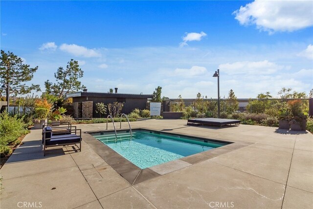 view of swimming pool featuring a patio area and a hot tub