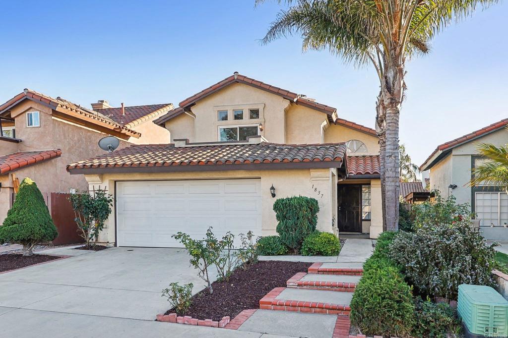 mediterranean / spanish-style house with a garage, fence, concrete driveway, a tiled roof, and stucco siding