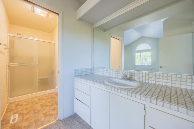 bathroom with lofted ceiling, a shower with shower door, backsplash, and vanity