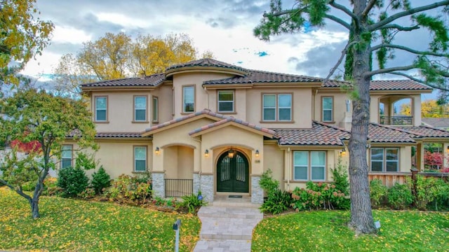 mediterranean / spanish-style house with french doors and a front yard