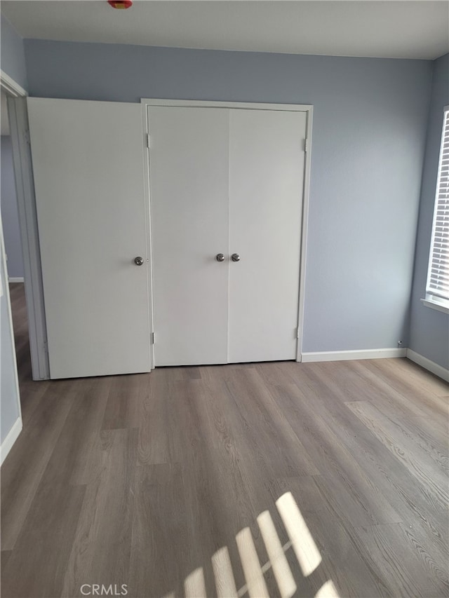 unfurnished bedroom featuring light hardwood / wood-style floors and a closet