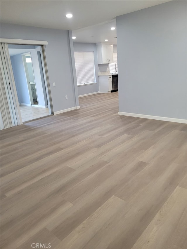 unfurnished living room with light wood-type flooring and sink