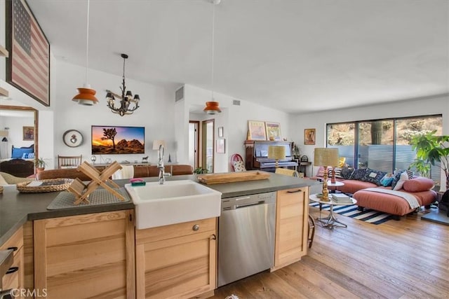 kitchen featuring open floor plan, a sink, light wood-type flooring, and stainless steel dishwasher