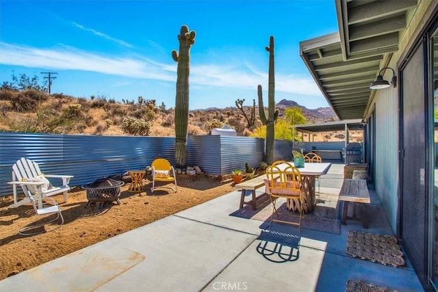 view of patio / terrace with an outdoor fire pit, outdoor dining area, and a fenced backyard