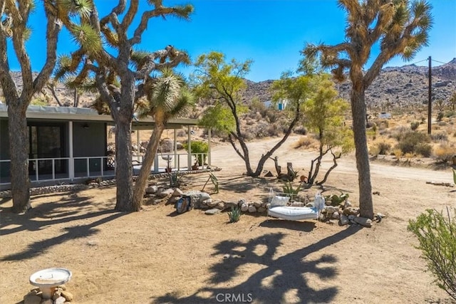 view of yard featuring a mountain view and a sunroom