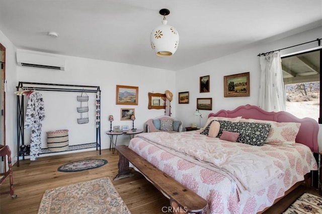 bedroom featuring access to outside, wood finished floors, and a wall mounted air conditioner