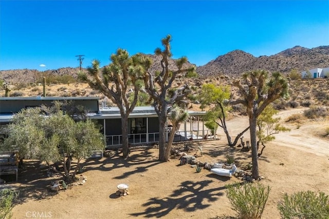 rear view of property featuring a mountain view and a sunroom