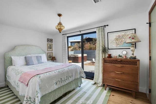 bedroom featuring access to outside, light wood-style floors, and baseboards