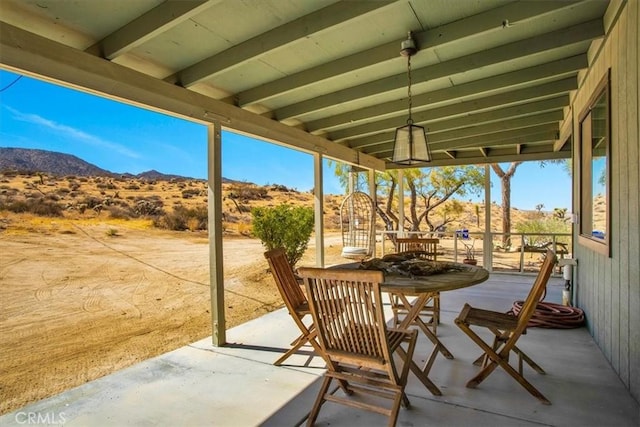 view of patio / terrace with outdoor dining space and a mountain view