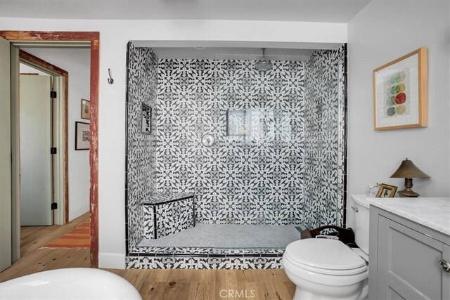 bathroom with vanity, a shower stall, toilet, and wood finished floors