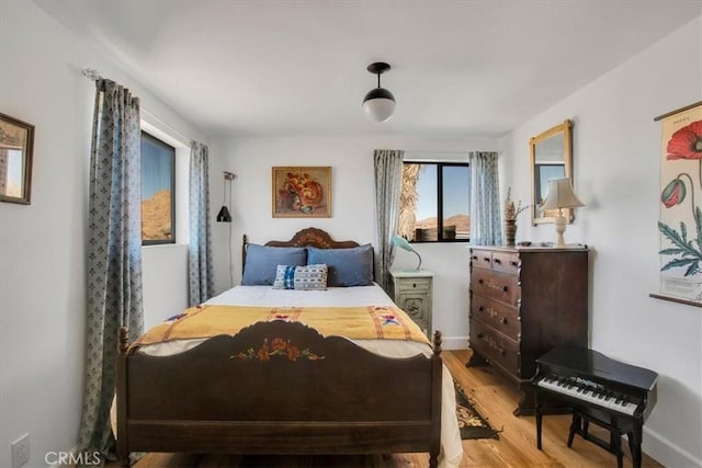 bedroom featuring wood finished floors and baseboards