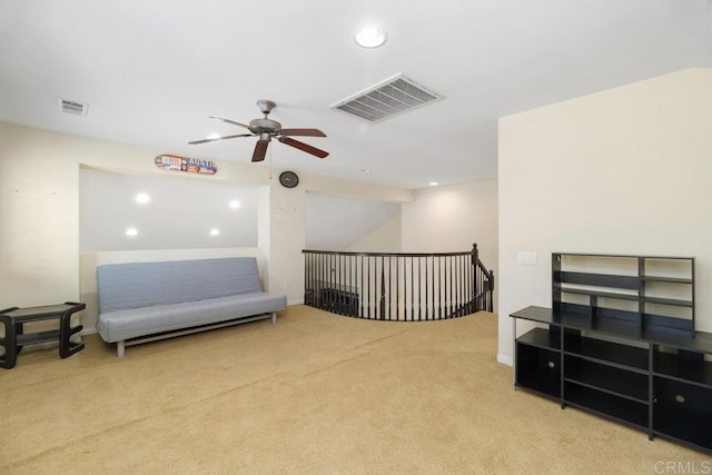 living area featuring light colored carpet and ceiling fan