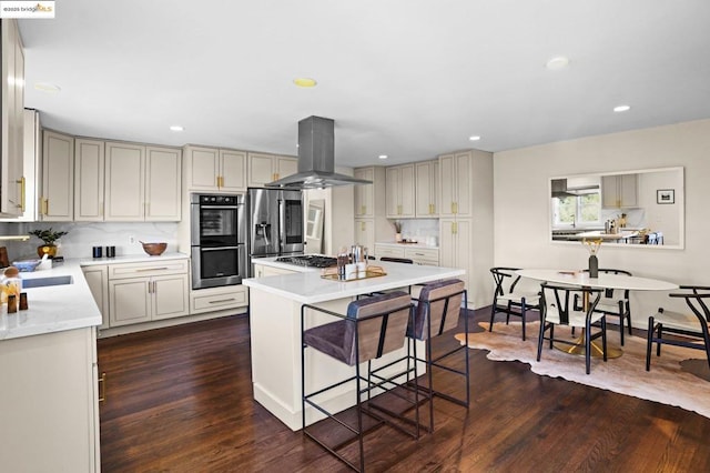 kitchen with stainless steel appliances, a breakfast bar, island exhaust hood, and dark wood-type flooring