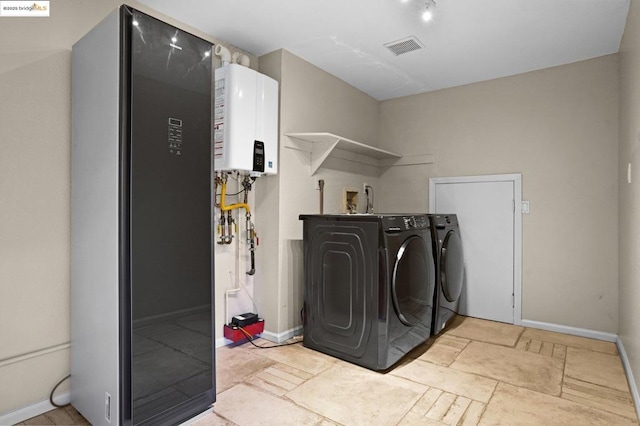 laundry room featuring washing machine and dryer, tankless water heater, and water heater