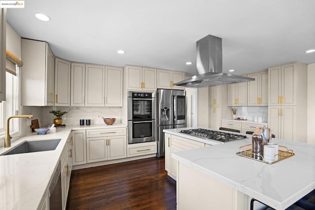 kitchen featuring light stone counters, island exhaust hood, a kitchen island, appliances with stainless steel finishes, and sink