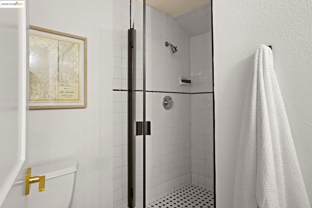 bathroom featuring a tile shower and toilet