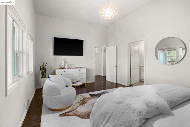 bedroom with a notable chandelier, dark hardwood / wood-style flooring, and ensuite bath