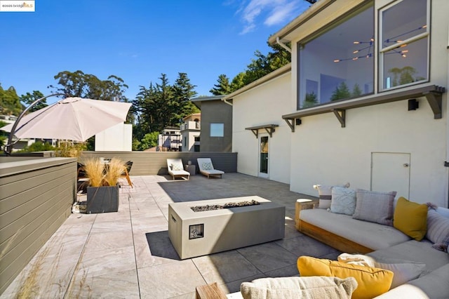 view of patio with an outdoor living space with a fire pit