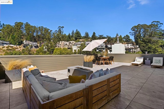 view of patio with an outdoor living space with a fire pit