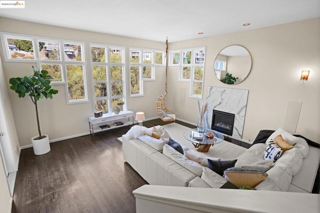 living room with dark wood-type flooring and a high end fireplace