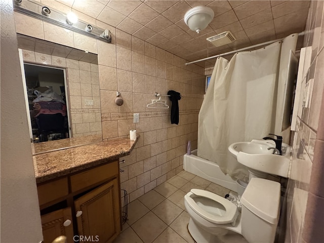 full bathroom featuring toilet, tile patterned flooring, tile walls, and shower / bathtub combination with curtain