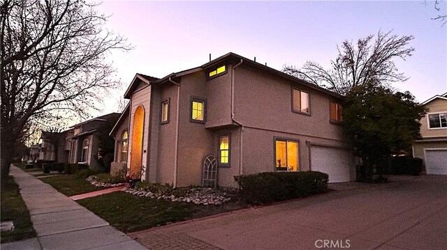 property exterior at dusk featuring a garage