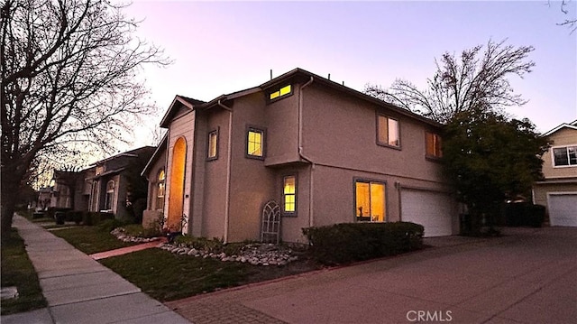 view of front facade with an attached garage and stucco siding