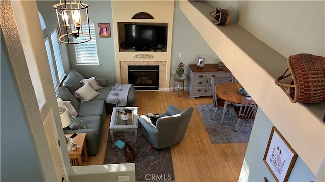 living room with a fireplace, wood finished floors, and a notable chandelier