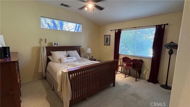 bedroom featuring lofted ceiling, multiple windows, visible vents, and light carpet