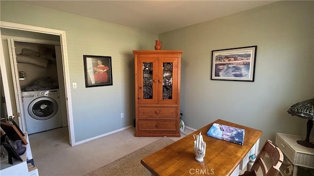 interior space featuring washer / dryer, light colored carpet, and baseboards