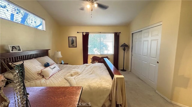 bedroom featuring lofted ceiling, a closet, a ceiling fan, light carpet, and baseboards