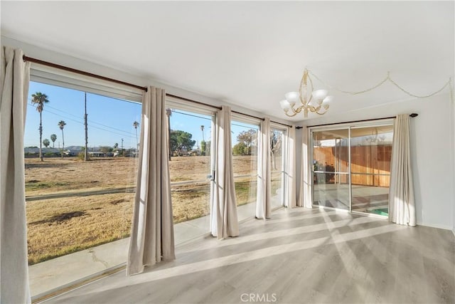 doorway with a notable chandelier and light hardwood / wood-style floors