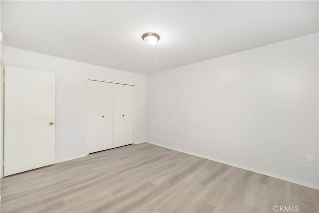 unfurnished bedroom with a closet and light hardwood / wood-style flooring