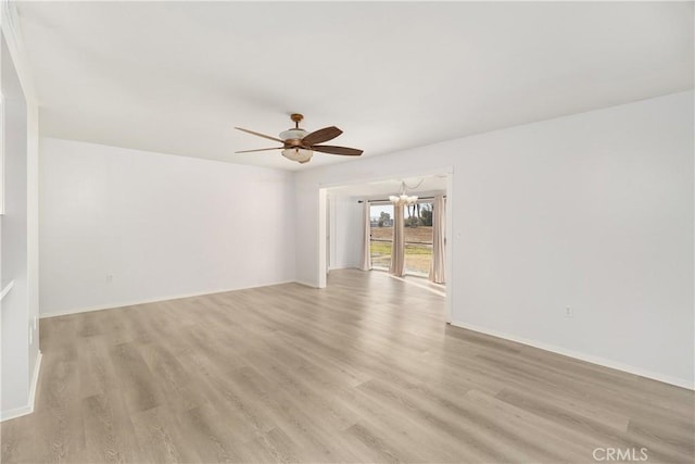 spare room featuring ceiling fan with notable chandelier and light wood-type flooring