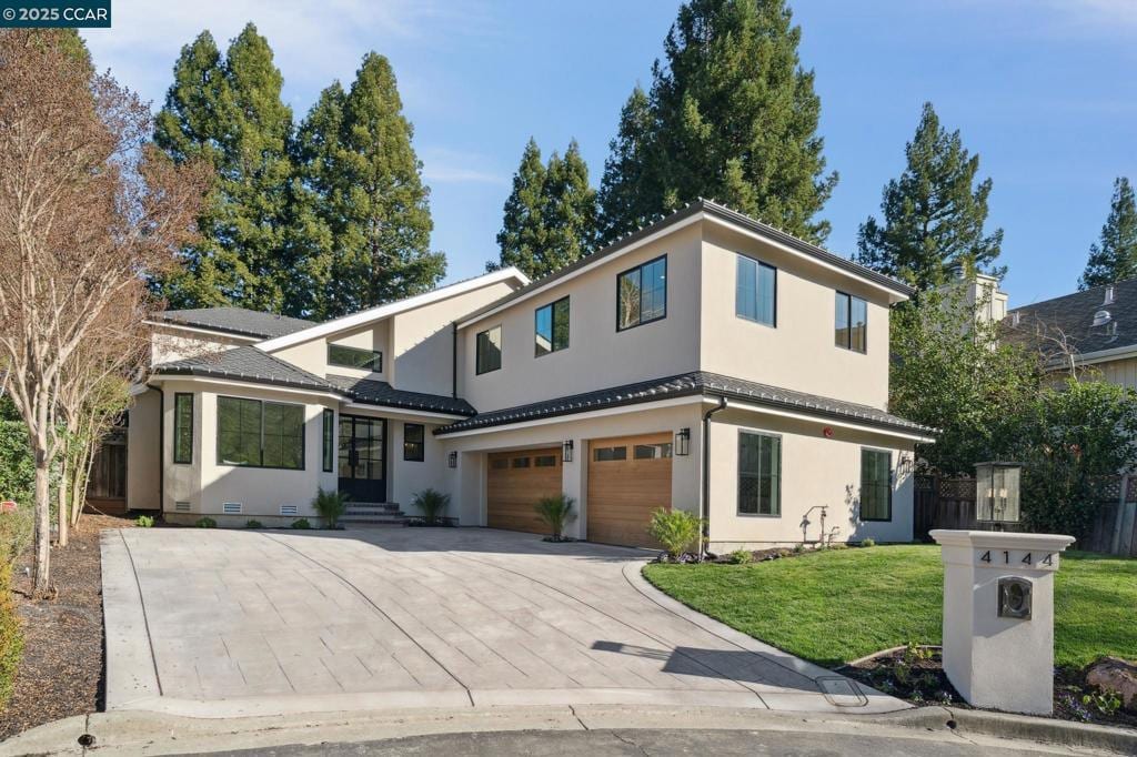 view of front of house featuring a garage and a front lawn