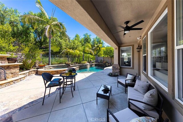 view of patio featuring a jacuzzi, a fenced in pool, ceiling fan, and a fenced backyard