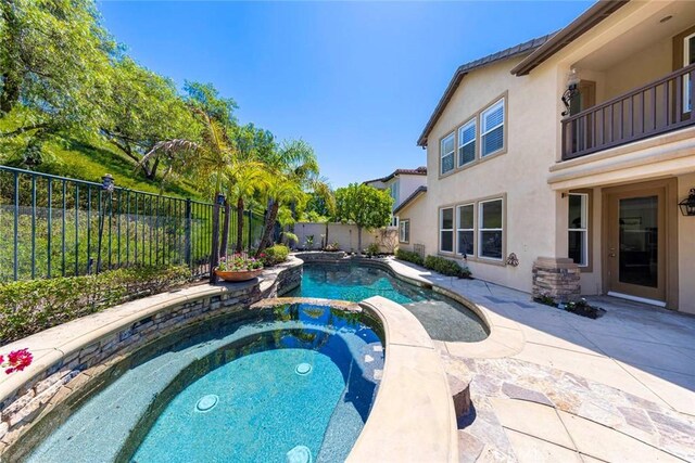 view of swimming pool with a patio area, a fenced backyard, and an in ground hot tub