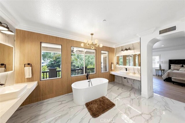 ensuite bathroom featuring a freestanding tub, marble finish floor, visible vents, and connected bathroom