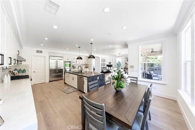 dining space with light wood-style floors, visible vents, crown molding, and recessed lighting