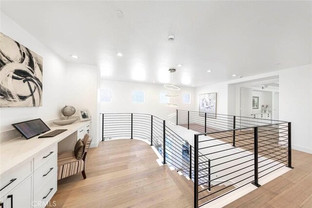 hallway with recessed lighting, light wood-style flooring, baseboards, and an upstairs landing