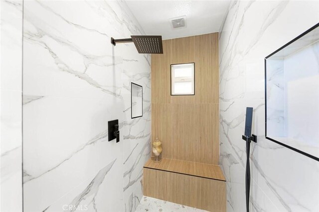 bathroom featuring a marble finish shower and visible vents