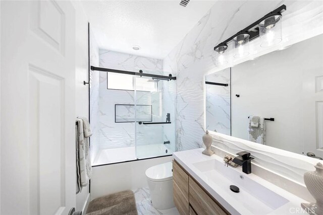 bathroom with toilet, marble finish floor, combined bath / shower with glass door, and vanity