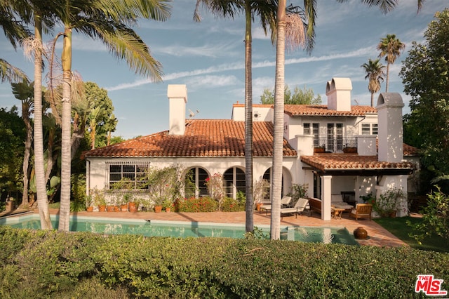 back of property featuring an outdoor hangout area, a balcony, and a patio