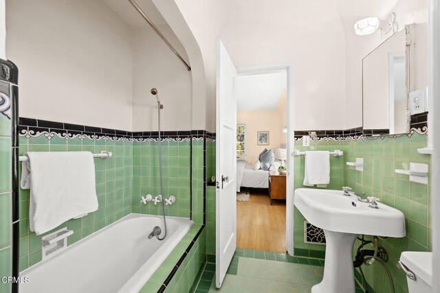 bathroom with tile walls, tile patterned floors, and toilet