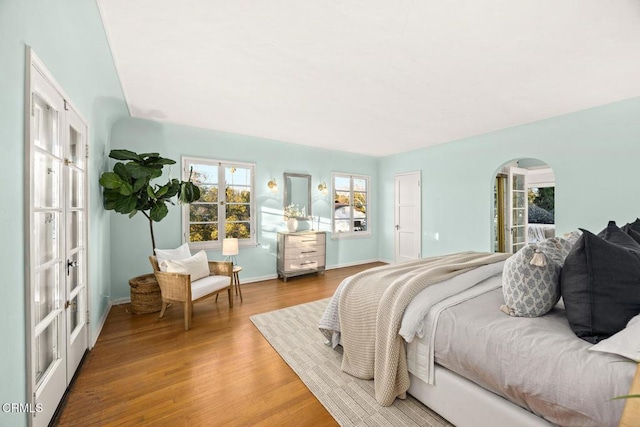 bedroom with french doors and hardwood / wood-style flooring